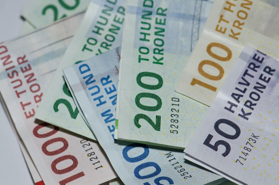 Danske pengesedler i en bunke, spredt fladt ud på et bord.