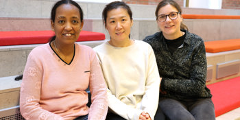 Tre dimittender fra Godt på Vej til SOSU sidder på en trappe.